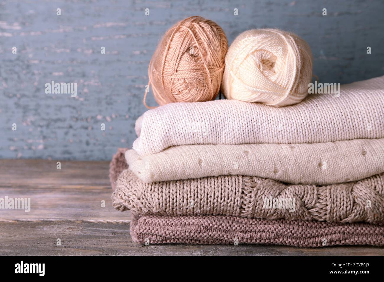 Vêtements de tricot et de fils sur fond de bois Banque D'Images