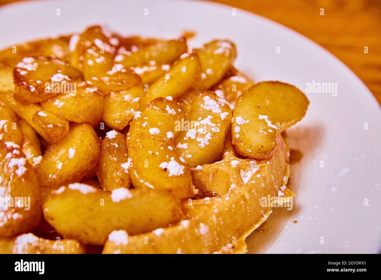 Gaufres appétissantes recouvertes de tranches de sirop de pomme et de sucre en poudre Banque D'Images