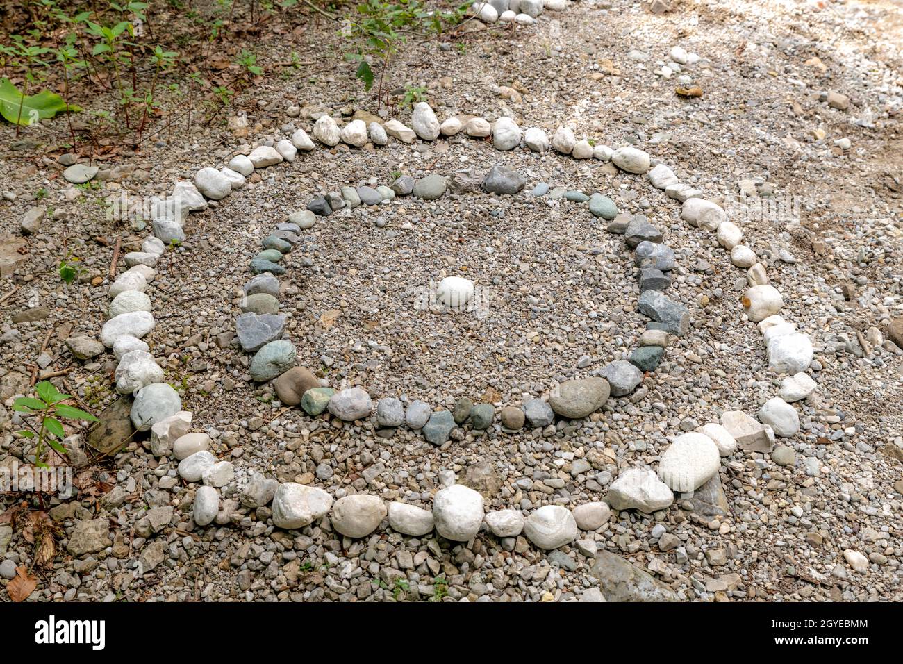 Cercles de galets blancs et gris sur la rive d'un ruisseau Banque D'Images