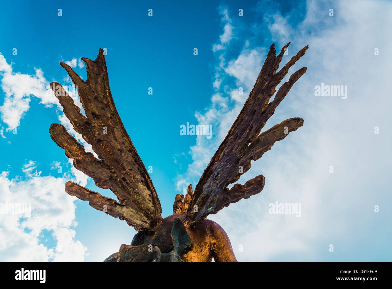 Une sculpture d'un ange, vue arrière de ses ailes contre le ciel. Banque D'Images