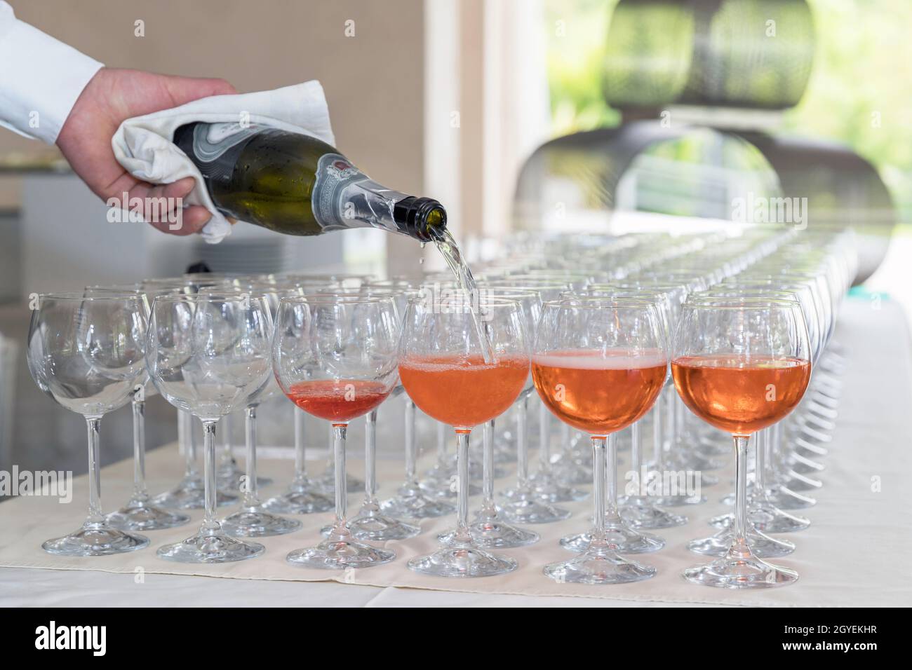 Cocktail de barman Spritz. Barman servant un cocktail de liqueur d'orange dans de nombreux verres de vin. Banque D'Images