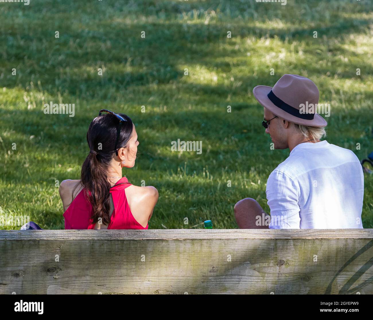 Vue arrière d'un jeune couple assis sur un banc dans un parc.Vue de rue, photo de voyage, mise au point sélective, photo concept relation homme et femme.Juillet Banque D'Images