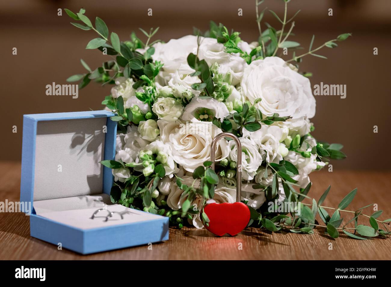 Composition des détails du matin de la mariée.Vue de dessus des anneaux de mariage, beau bouquet de fleurs roses avec rubans.Pose à plat. Banque D'Images