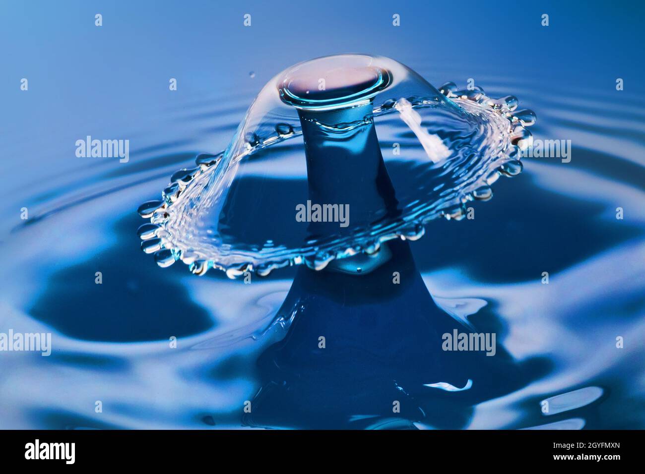 Magnifique parapluie d'eau de collision d'eau sur l'eau bleue Banque D'Images