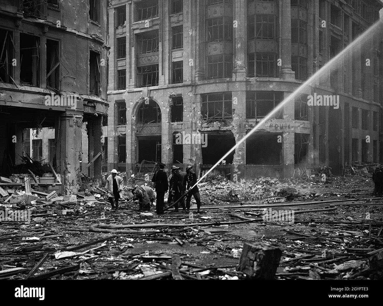 Des pompiers vaporisant de l'eau sur des bâtiments en feu pendant le Blitz, Londres, 1940 Banque D'Images