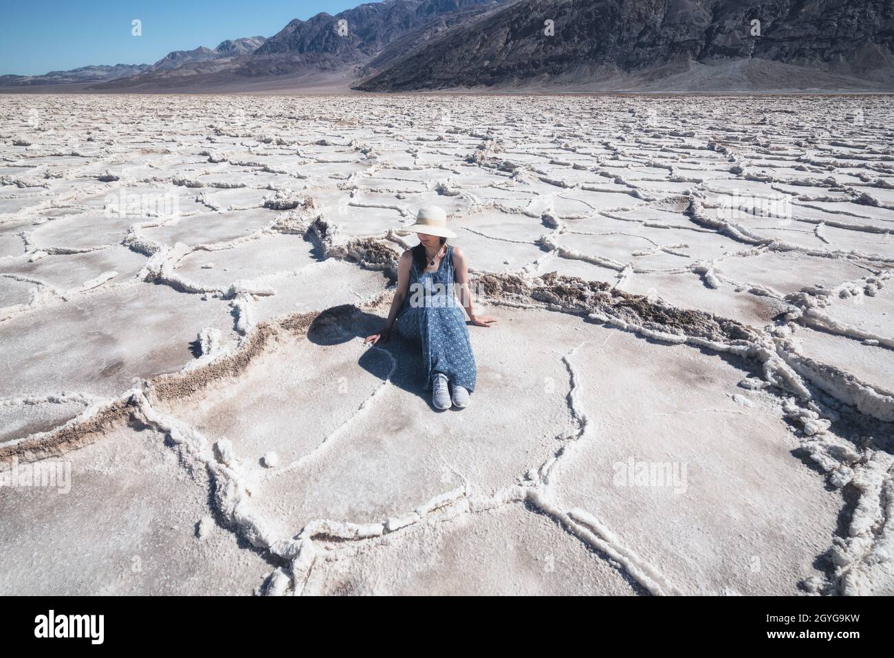 Salt Flats dans le parc national de la Vallée de la mort. Silhouette d'une femme qui profite de la vue. Sentier de randonnée de Badwater Basin, aventure de sentier à travers les plaques de sel bouleversements Banque D'Images