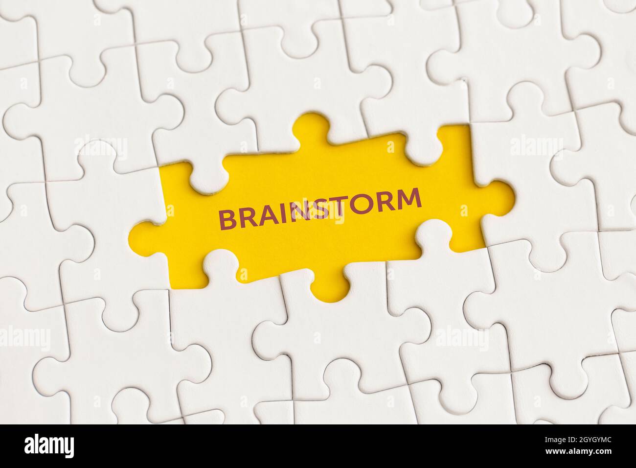 Détails blancs du puzzle avec le texte « Brainstorm » sur fond jaune. Banque D'Images