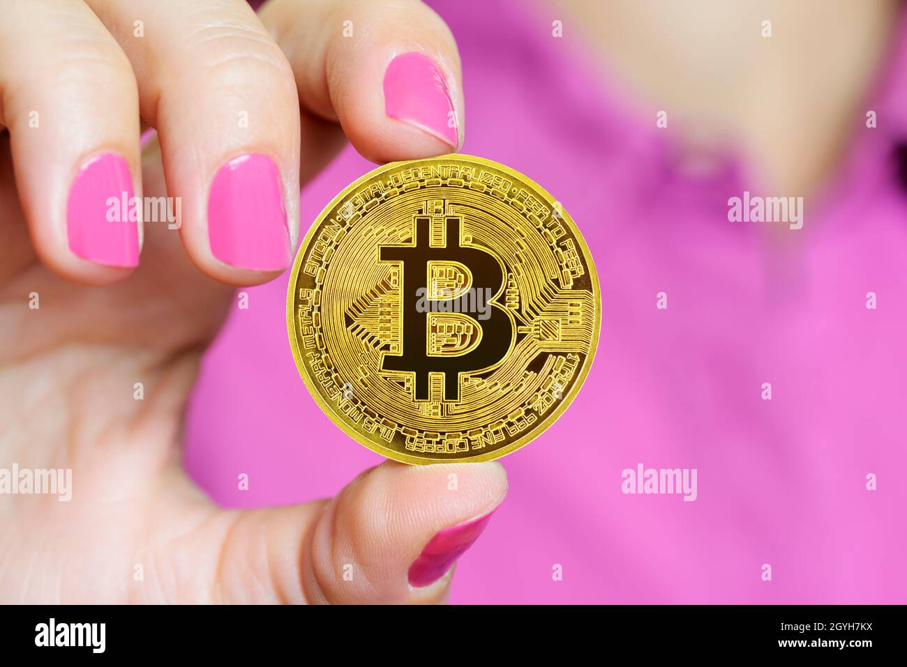 Bitcoin crypto-monnaie pièce tenue entre les doigts des femmes Banque D'Images
