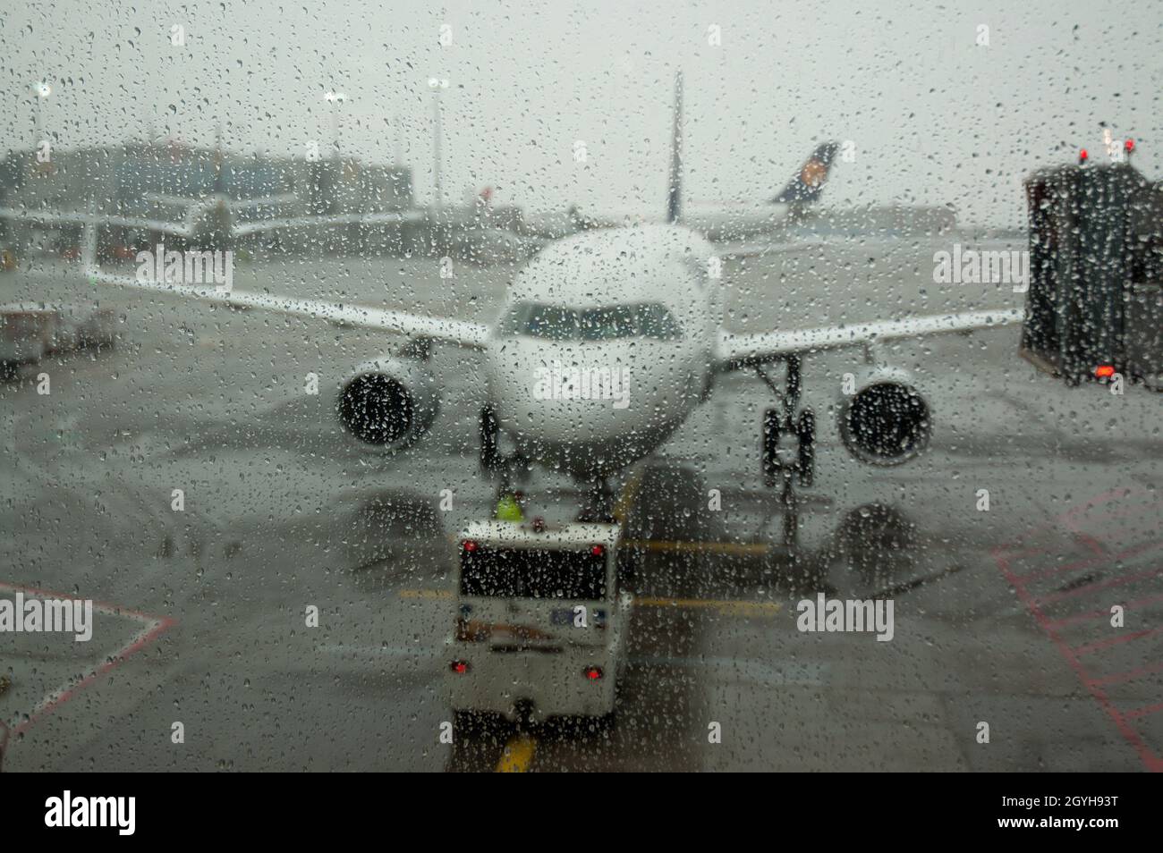 Avion sur piste vu par fenêtre humide le jour de pluie - concentrez-vous sur les gouttes d'eau sur la fenêtre Banque D'Images