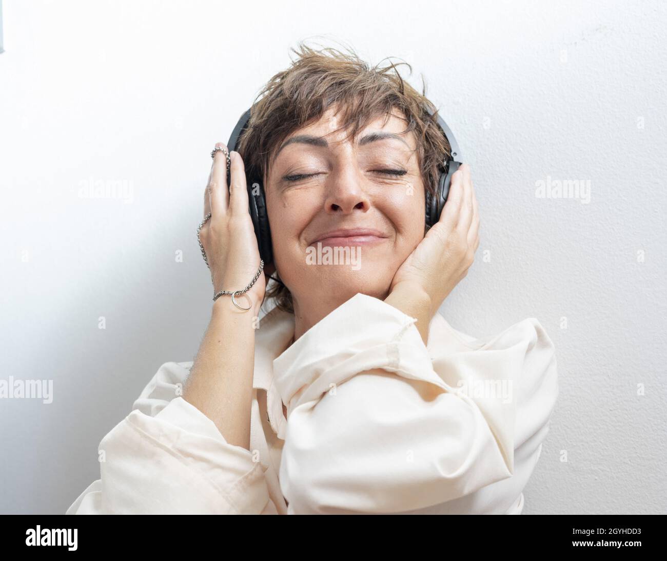 Une femme excitée écoute de la musique avec son casque Banque D'Images