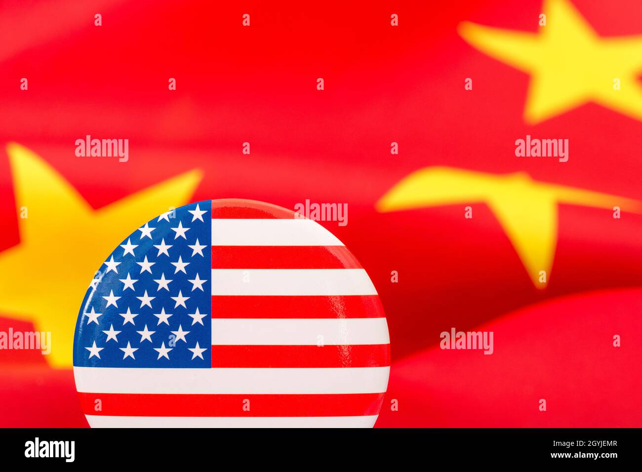 Bouton étoiles et rayures placé contre jaune et rouge du drapeau de la Chine. Pour le différend entre les États-Unis et la Chine, la délocalisation des emplois américains en Chine, la métaphore du Centre de mission américain en Chine. Banque D'Images