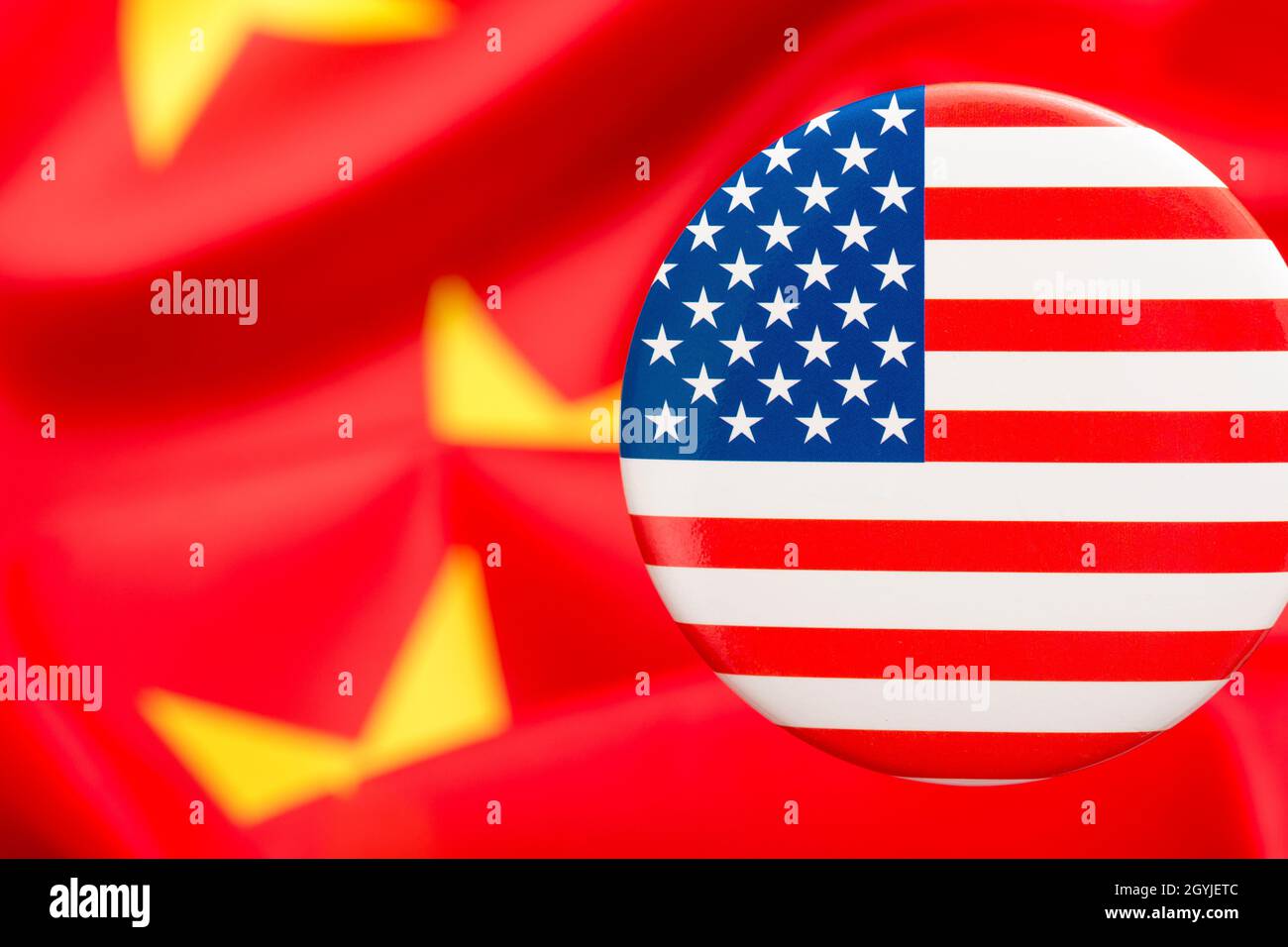 Bouton étoiles et rayures placé contre jaune et rouge du drapeau de la Chine. Pour le différend entre les États-Unis et la Chine, la délocalisation des emplois américains en Chine, la métaphore du Centre de mission américain en Chine. Banque D'Images