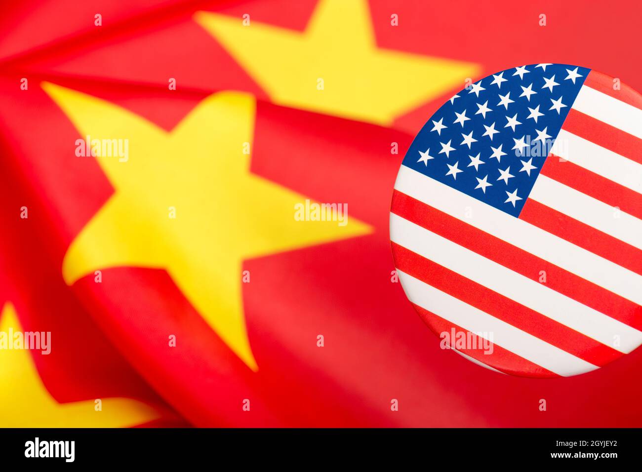 Bouton étoiles et rayures placé contre jaune et rouge du drapeau de la Chine. Pour le différend entre les États-Unis et la Chine, la délocalisation des emplois américains en Chine, la métaphore du Centre de mission américain en Chine. Banque D'Images