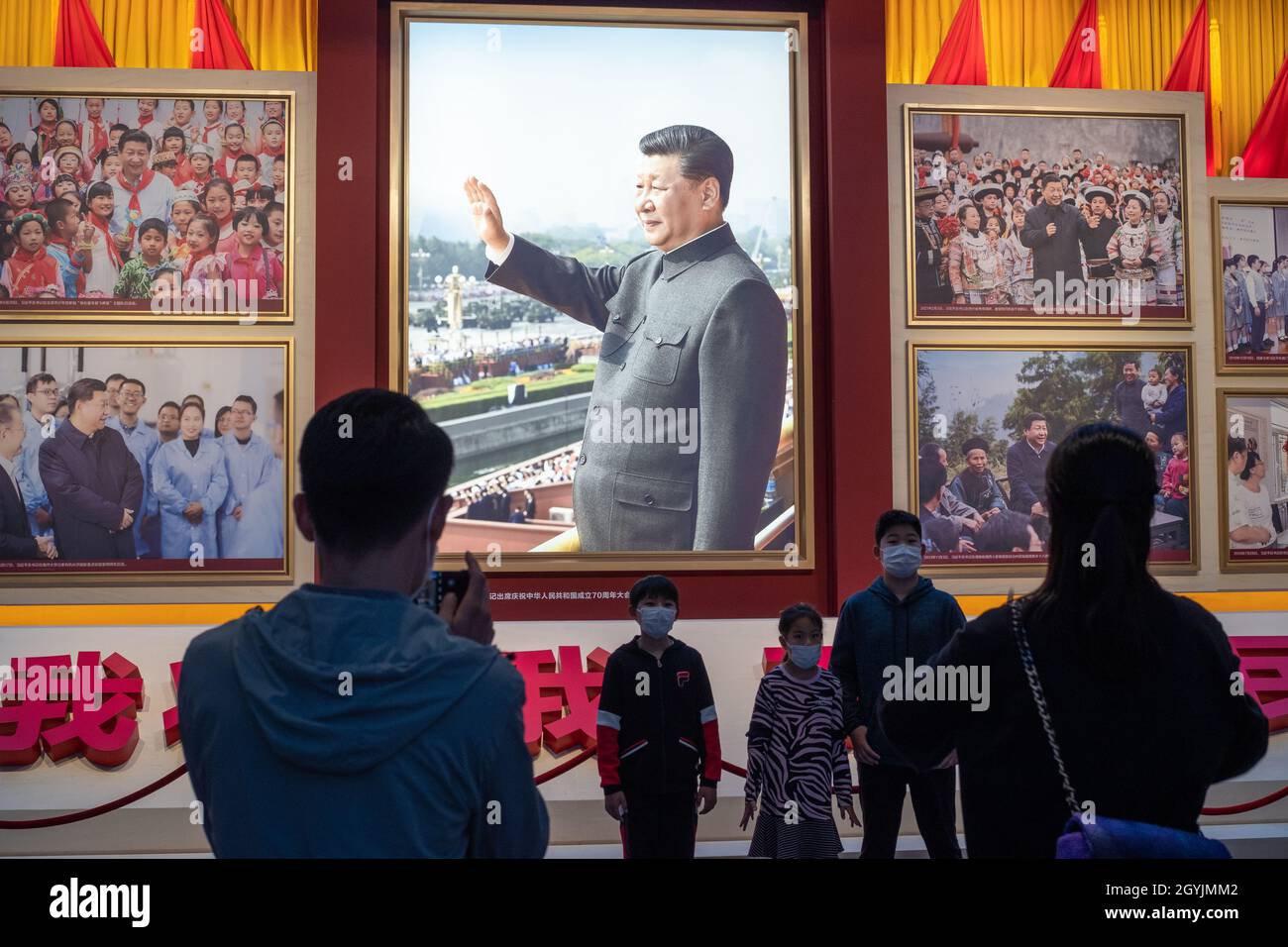 Les gens regardent des images montrant le président chinois Xi Jinping au Musée du Parti communiste de Chine à Beijing.08 octobre 2021 Banque D'Images
