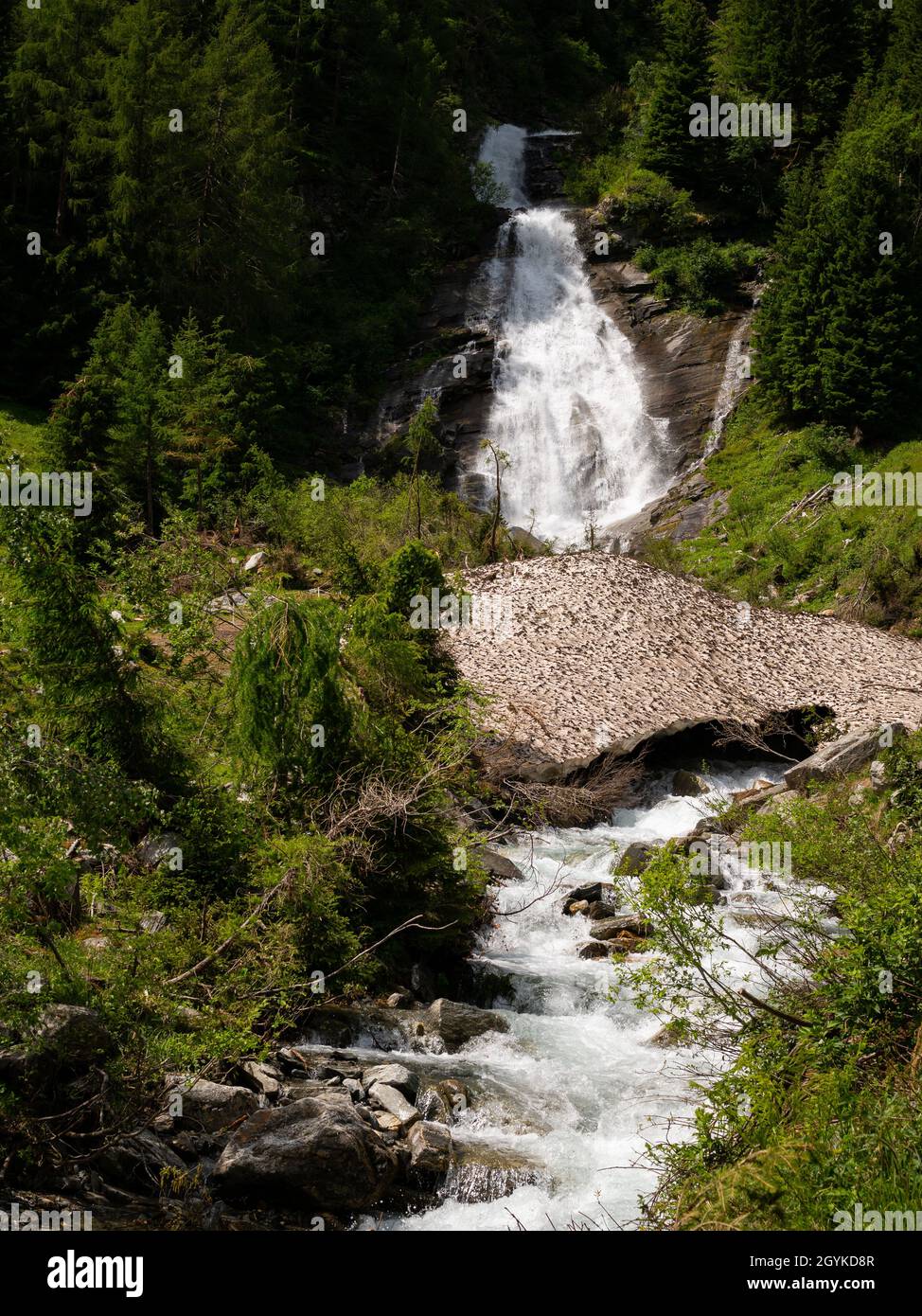 Cascade partiellement couverte de restes de neige, jour ensoleillé au début de l'été, Tyrol oriental (Autriche) Banque D'Images