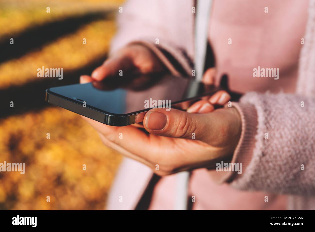 Femme tenant un smartphone moderne entre ses mains et utilisant les réseaux sociaux. Banque D'Images