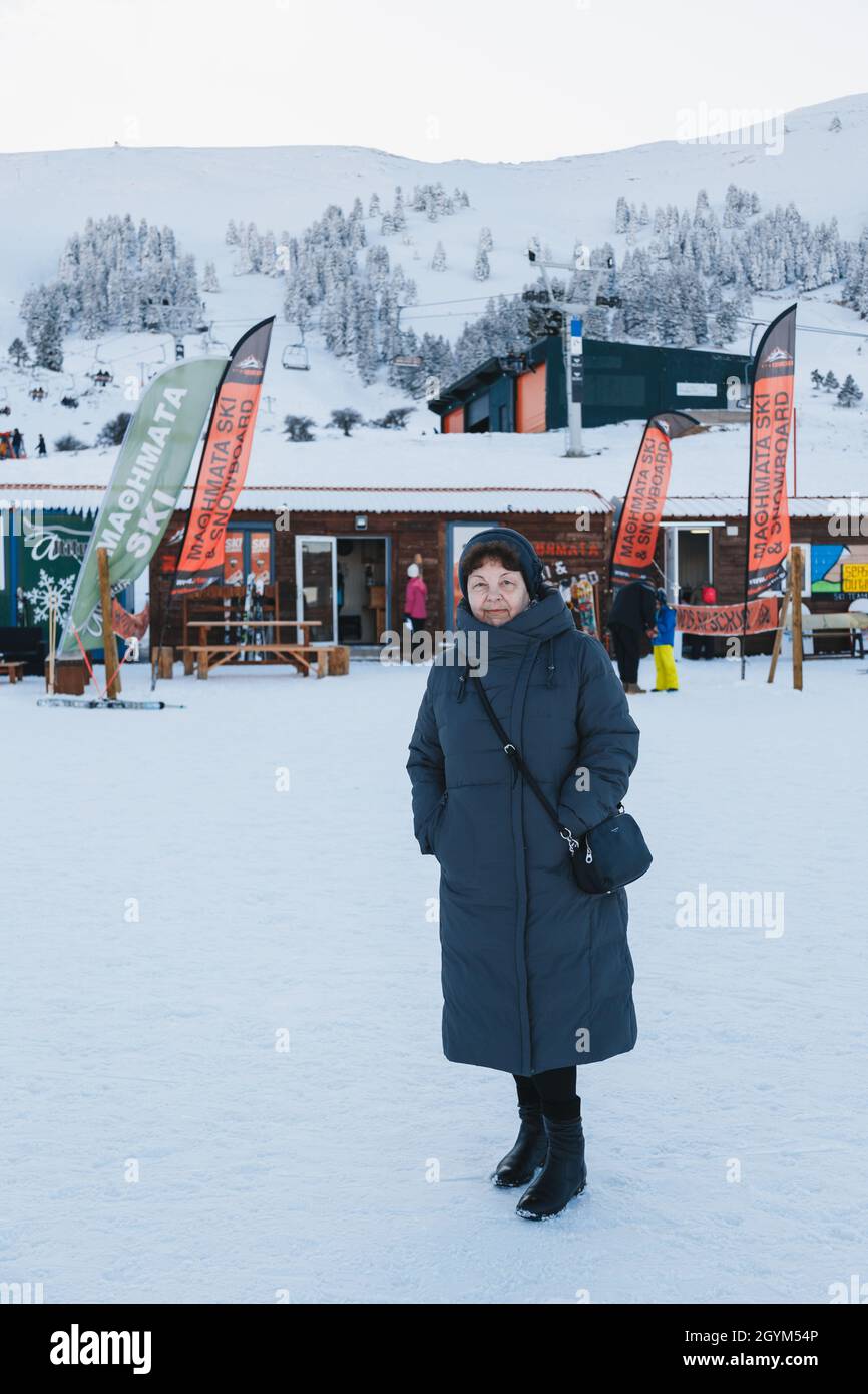 Kalavryta ski Resort, Grèce - janvier, 1 2020: Femme sénior belle en manteau  long gris au centre de location de station de ski avec vue sur les  montagnes enneigées Photo Stock - Alamy