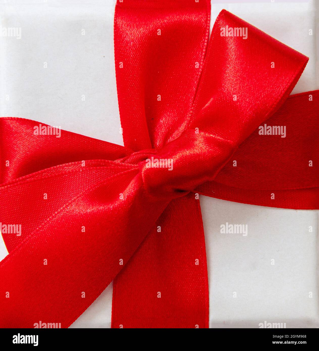 Ruban rouge cadeau avec noeud isolé sur fond blanc, Noël ou Valentin présente décoration curly en satin, élément design, vue du dessus. Banque D'Images
