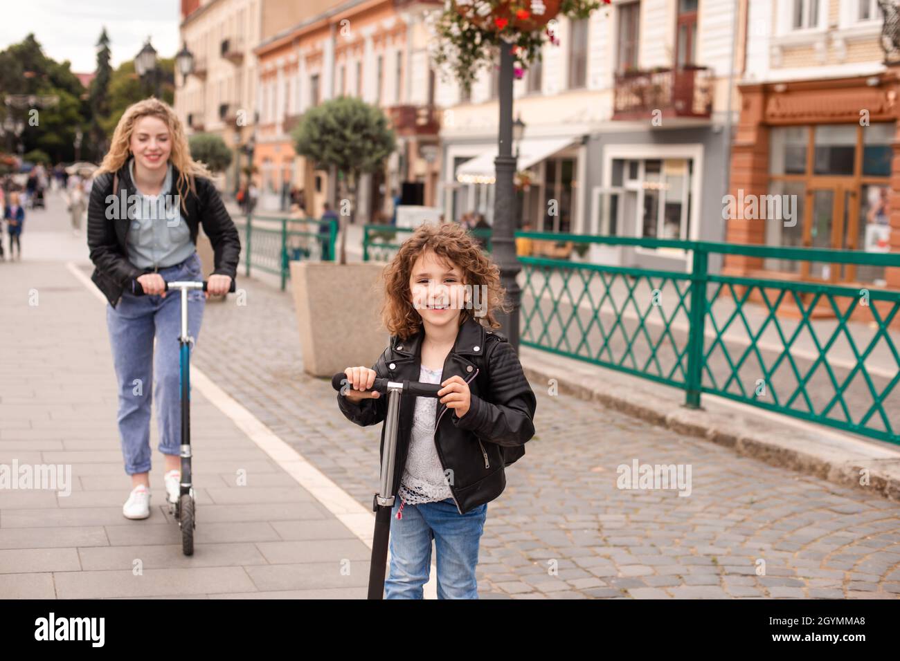 La jeune fille fait un scooter pour la première fois avec sa mère Photo Stock Alamy