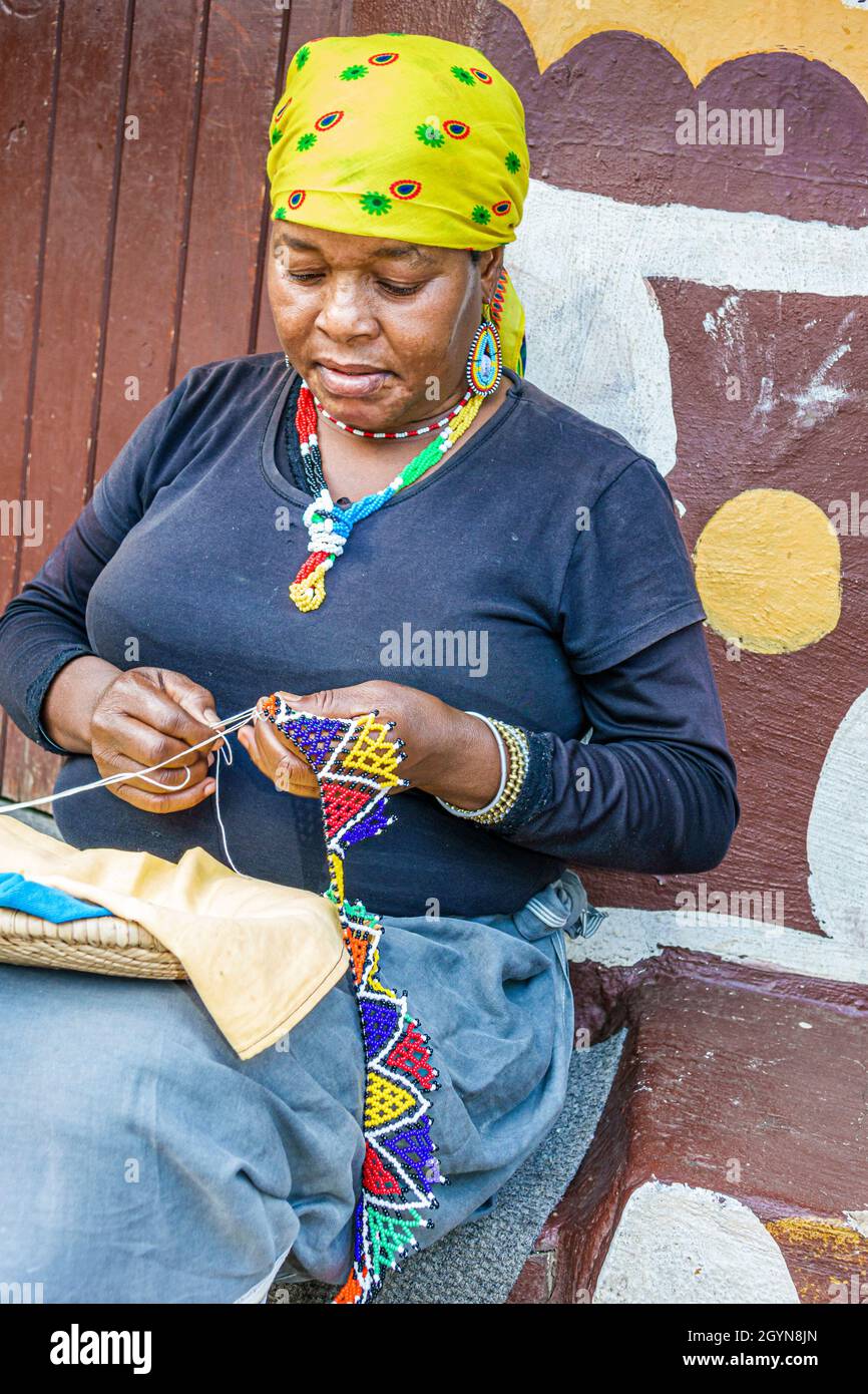 Johannesburg Afrique du Sud, Lesedi African Lodge & Cultural Village, Zulu Xhosa Pedi Basotho tribu Ndebele, Black Woman making perles collier Banque D'Images