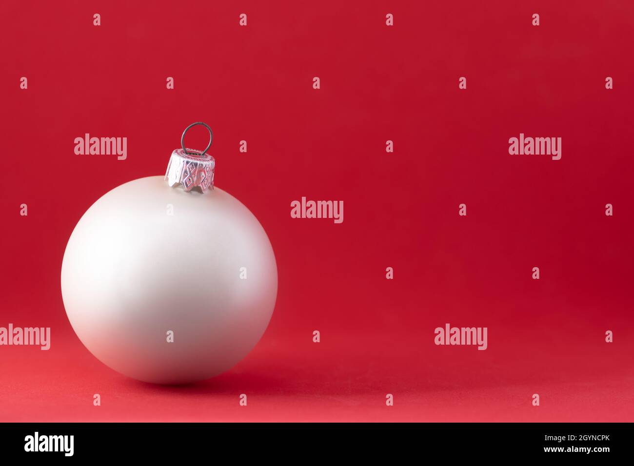 Boule de Noël sur fond rouge.Espace de texte sur la carte de Noël avec boule de Noël blanche.Décoration de noël rouge élégante.Joyeux Noël et Banque D'Images