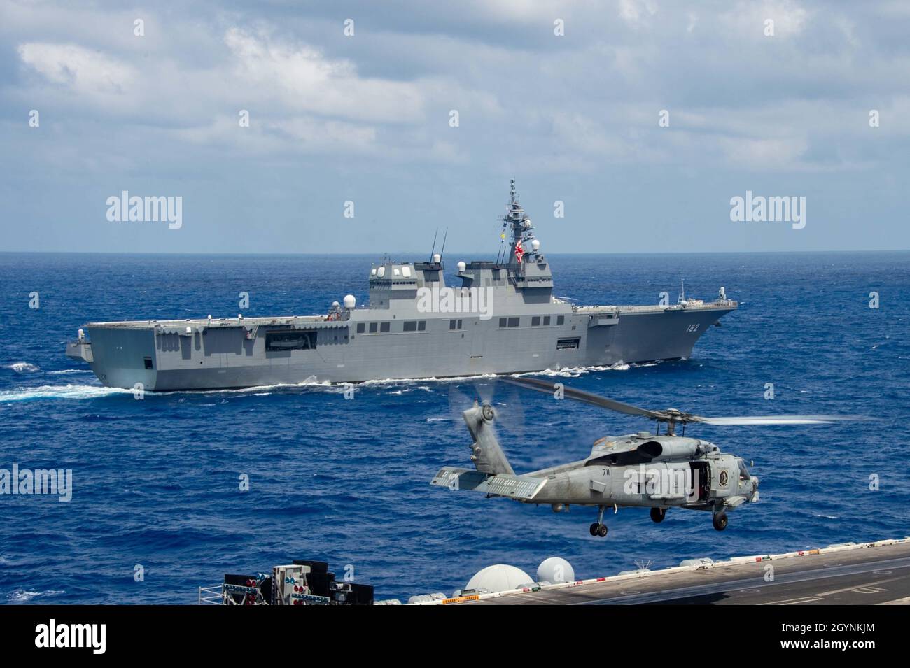 211003-N-RO680-1259 MER DES PHILIPPINES (OCT3, 2021) les Forces d'autodéfense maritimes du Japon (JMSDF) le destroyer hélicoptère de classe Hyuga JS ISE (DDH 182) transite à côté du porte-avions de classe Nimitz USS Carl Vinson (CVN 70), le 3 octobre 2021.Le groupe de grève des transporteurs du Royaume-Uni dirigé par le HMS Queen Elizabeth (R08); la JMSDF dirigée par le destroyer d’hélicoptère de classe Hyuga JS ISE (DDH 182); le NCSM Winnipeg de la Royal Canadian Navy (FFH 338); le HNLMS Evertsen de la Royal Netherlands Navy (F 805);HMNZS te Kaha (F 77) de la Royal New Zealand Navy et les groupes de grève des transporteurs de la marine américaine dirigés par les navires de garde USS Ronald Reagan (CVN 76) et US Banque D'Images