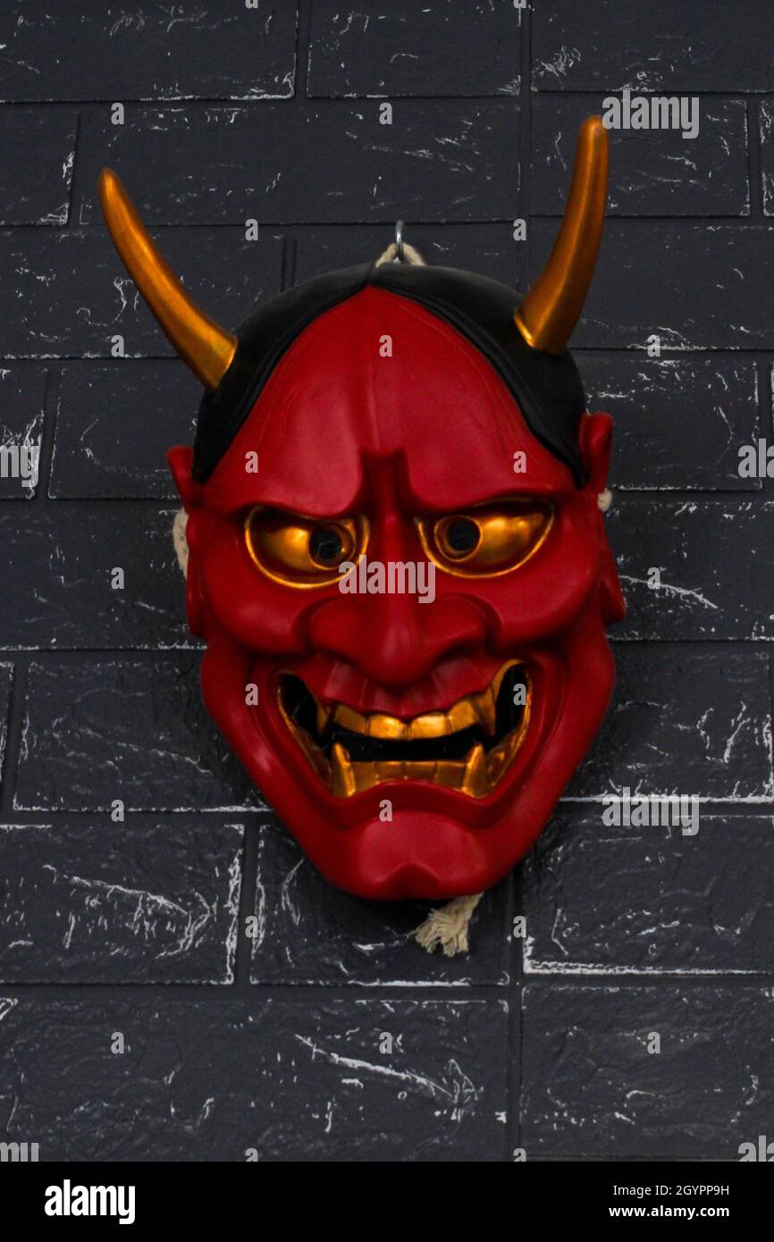 Photo verticale d'un masque de diable pour Halloween sur un mur Banque D'Images