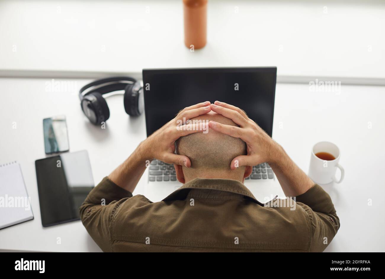 Homme stressé et fatigué inquiet des problèmes et des erreurs assis au bureau avec un ordinateur portable Banque D'Images