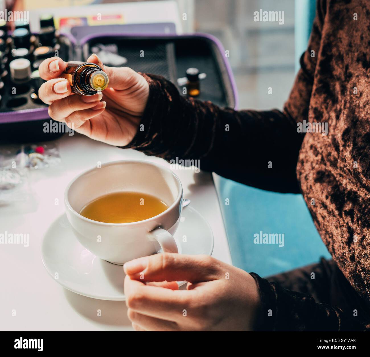 ajouter de l'huile saine dans une tisane de fruit les mains de gros plan Banque D'Images