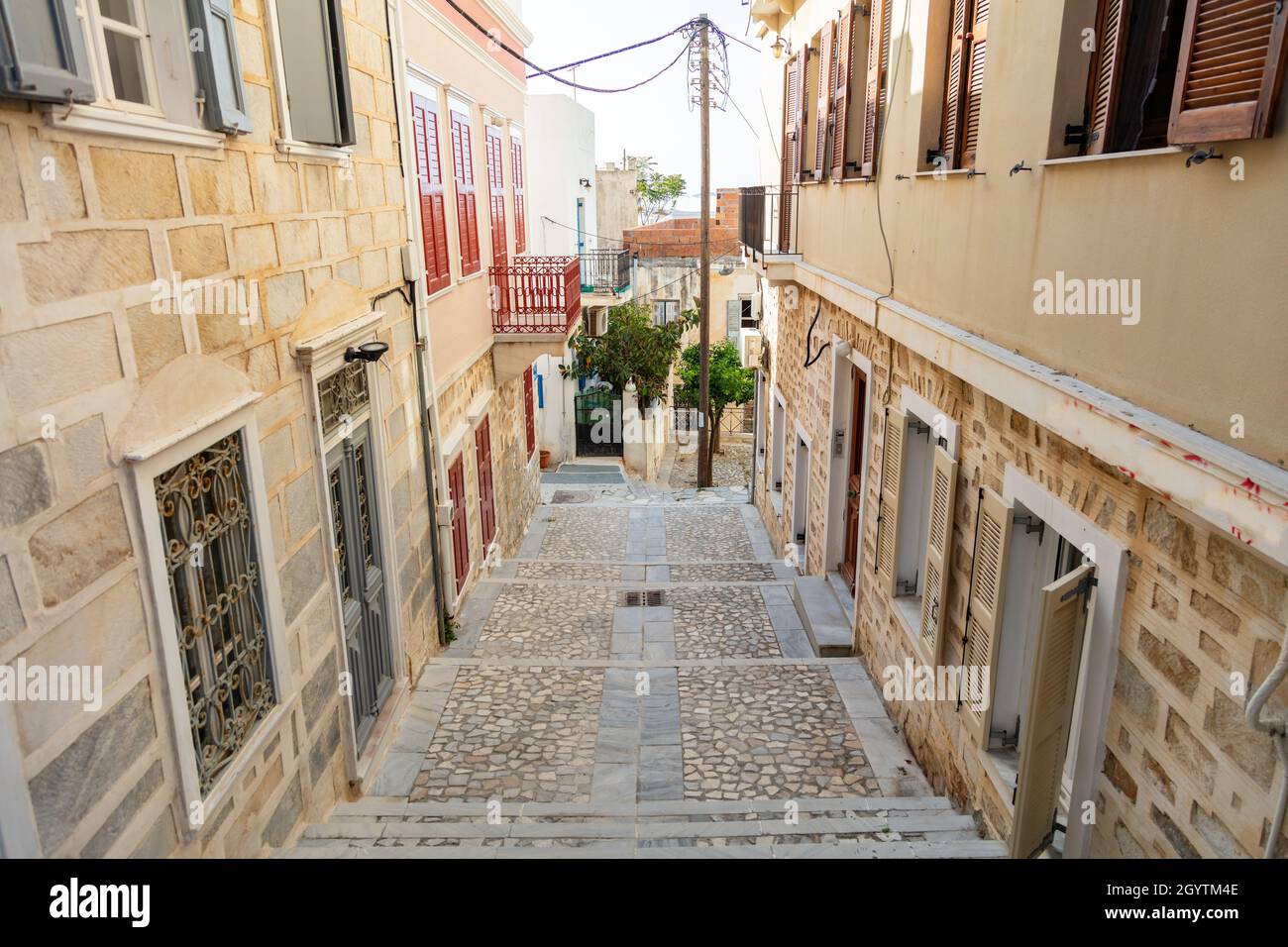 Découverte de l'architecture des îles Cyclades.Maisons traditionnelles murs en pierre marbre balcons volets en bois pavés ruelles étroites et escaliers verts Banque D'Images