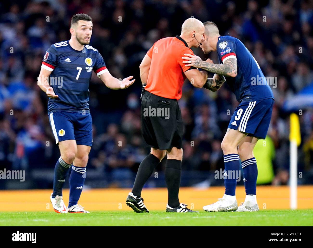 Lyndon Dykes (à droite), en Écosse, parle à l'arbitre Szymon Marciniak après que son but ait été rejeté avant que la décision ne soit plus prise par VAR lors du match de qualification de la coupe du monde de la FIFA à Hampden Park, Glasgow.Date de la photo: Samedi 9 octobre 2021. Banque D'Images