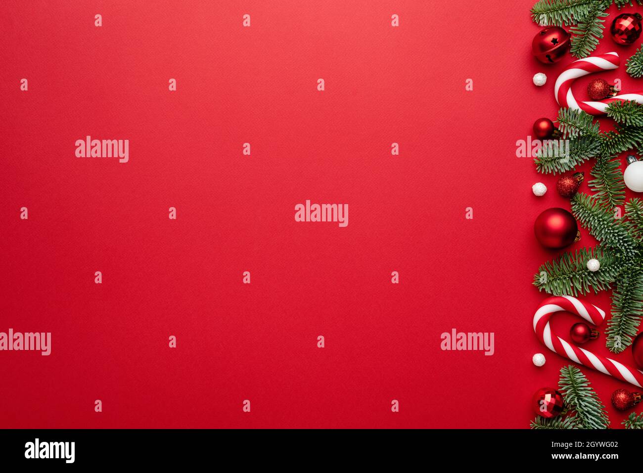 Arrière-plan rouge avec bordure de Noël, boules de Noël, et une canne à sucre pour le motif de Noël.Vide avec un espace de copie pour le texte Banque D'Images