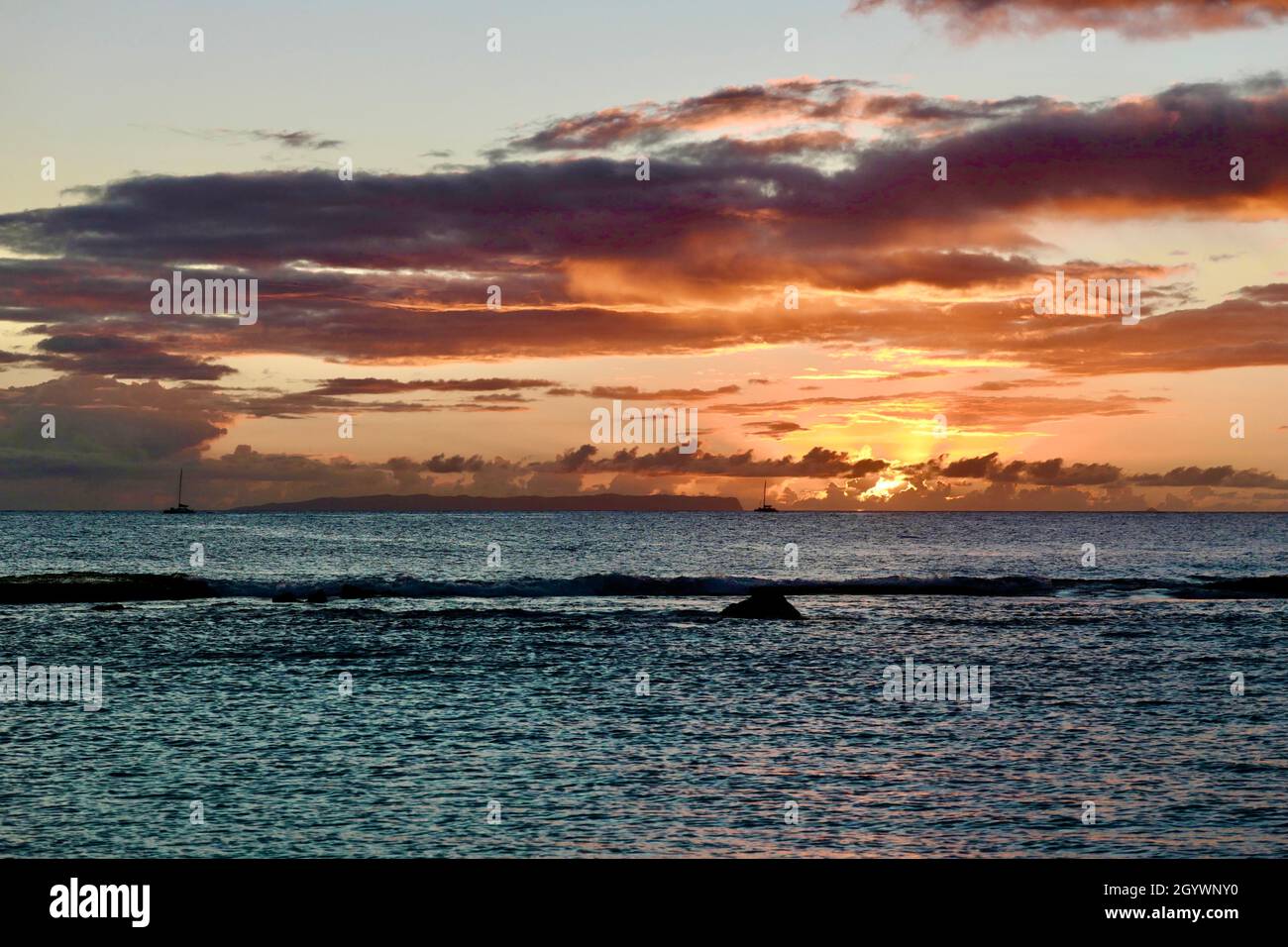 Des bateaux revenant de la côte de Napali s'arrêtent devant l'île interdite de Niihau pour observer le coucher du soleil Banque D'Images