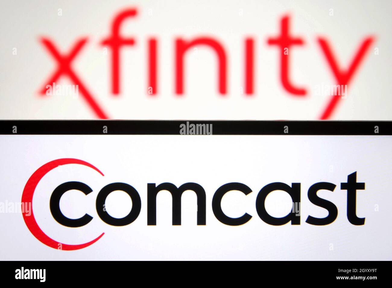 Dans cette illustration, un logo Comcast apparaît sur l'écran d'un smartphone avec un logo Xfinity en arrière-plan. Banque D'Images