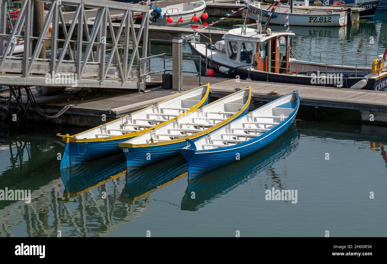 Newlyn Harbour, Cornwall, Angleterre, Royaume-Uni.2021. Trois bateaux-pilotes de gig sur une jetée dans le port de Newlynn. Banque D'Images