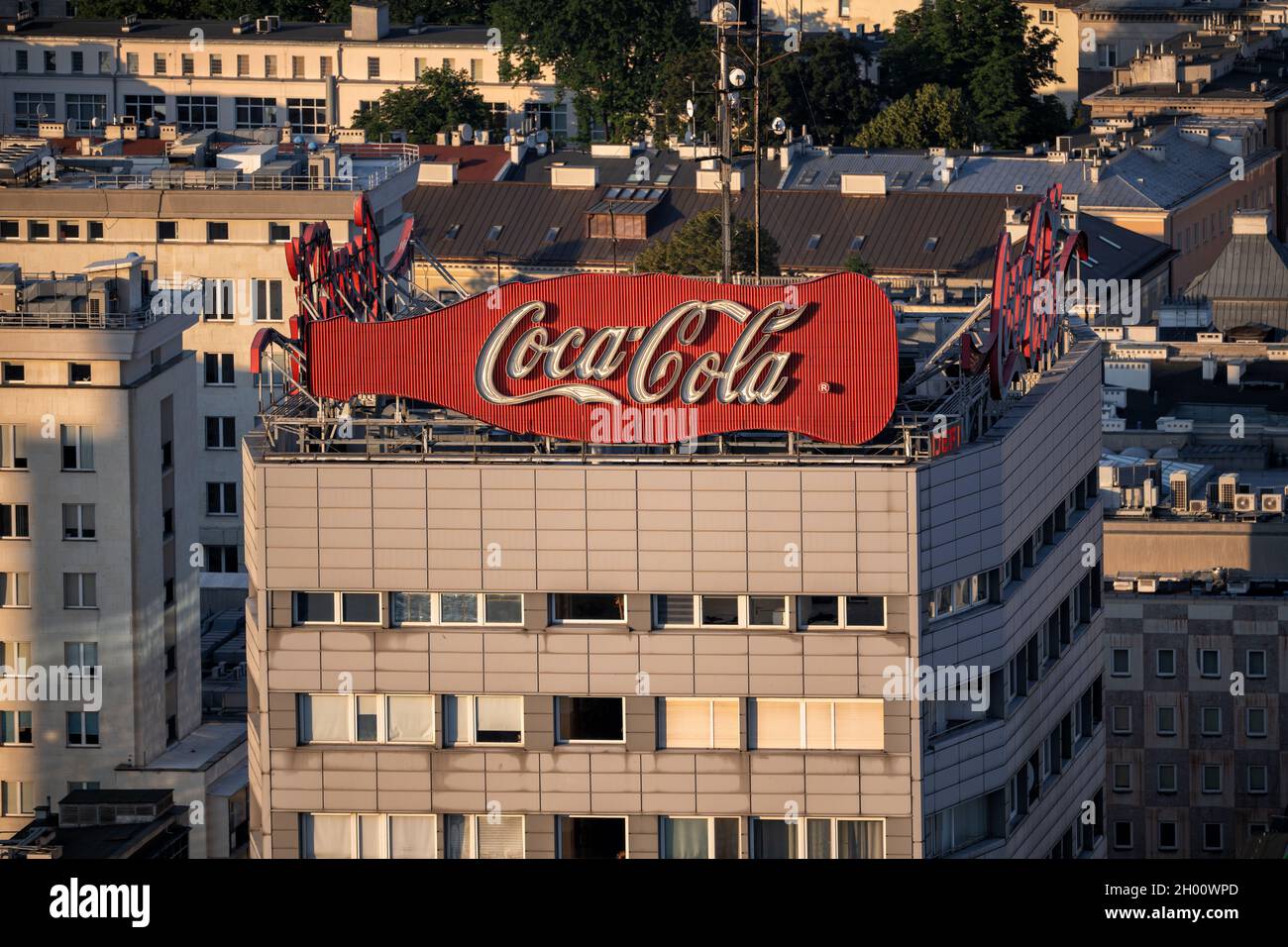 Coca Cola classique vintage néon signe au coucher du soleil sur le dessus de la tour résidentielle dans le centre-ville de Varsovie en Pologne. Banque D'Images