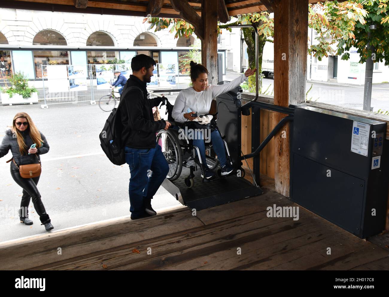 Ascenseur accessible en fauteuil roulant utilisé par une jeune femme sur le pont de la chapelle de Lucerne, en Suisse Banque D'Images