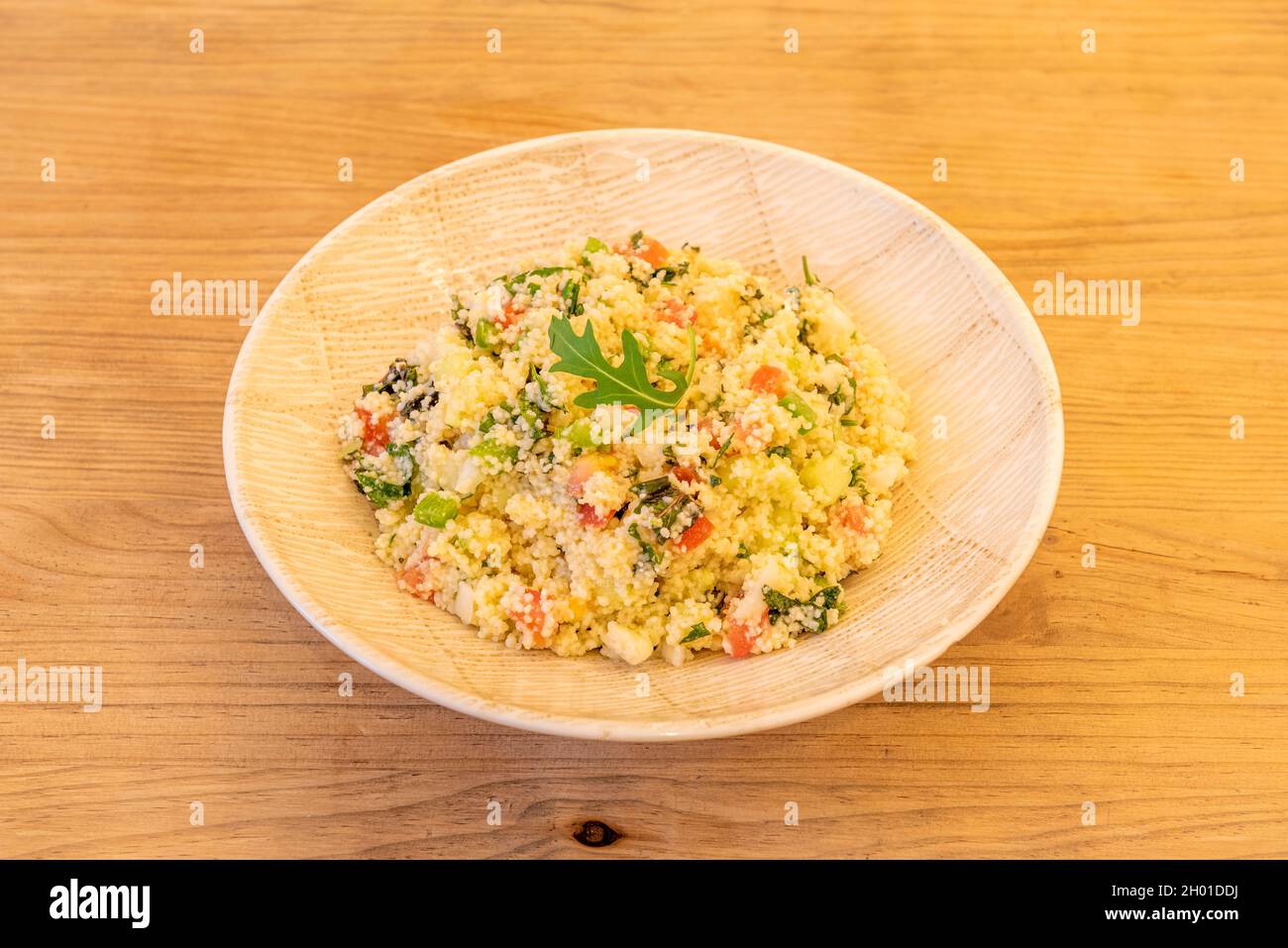Assiette en bois avec recette pour tabouleh de légumes avec huile d'olive sur table en bois Banque D'Images