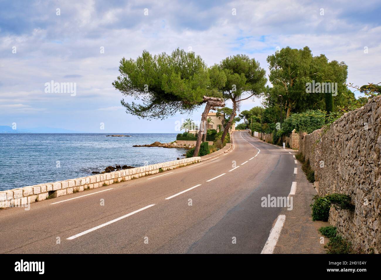 Une route étroite courbe serpente le long de la rive de la Méditerranée sur la Côte d'Azur, Antibes France. Banque D'Images