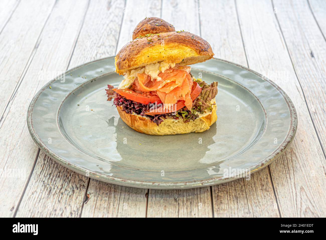 Sandwich pain brioche au saumon fumé, tranches de tomate, laitue chêne au fromage  frais et origan Photo Stock - Alamy