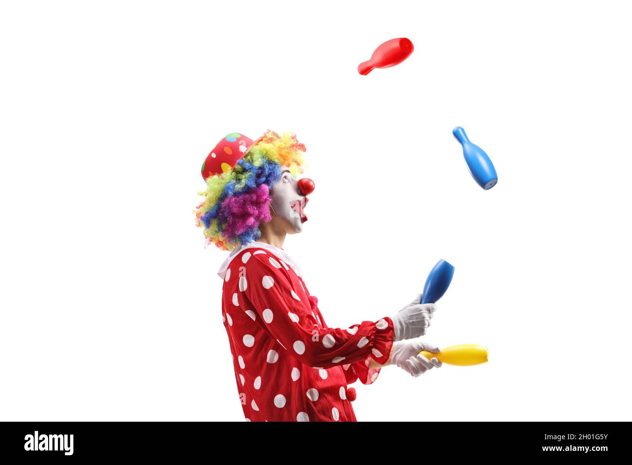 Photo de profil d'un clown jonglant avec des clubs isolés sur fond blanc Banque D'Images