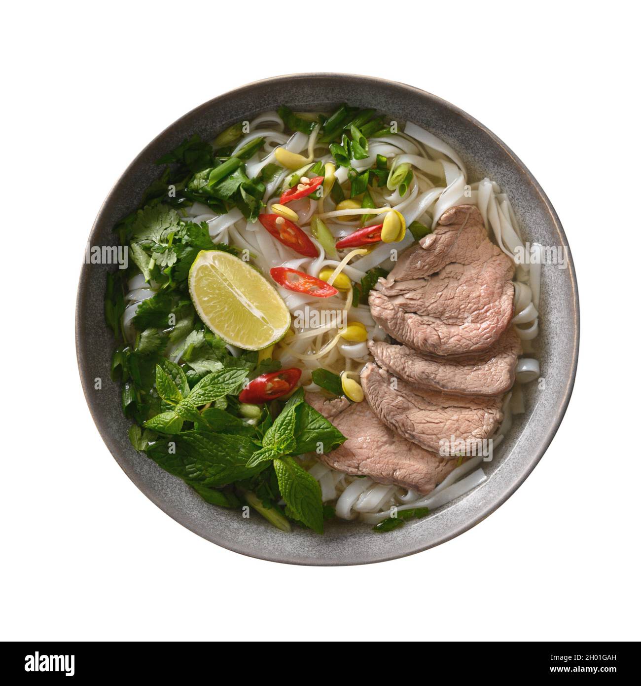 Soupe de Pho Bo avec bœuf, nouilles de riz, citron vert, piment dans un bol gris isolé sur la dorure blanche.Cuisine vietnamienne. Banque D'Images