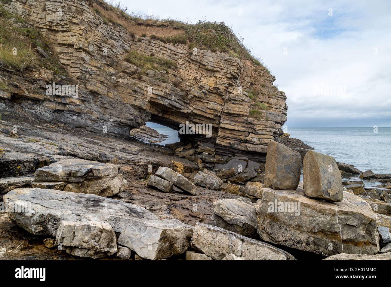 Le pont de la mer à Penmon point sur la côte nord du pays de Galles où la force de la mer a creusé un trou dans la côte rocheuse. Banque D'Images