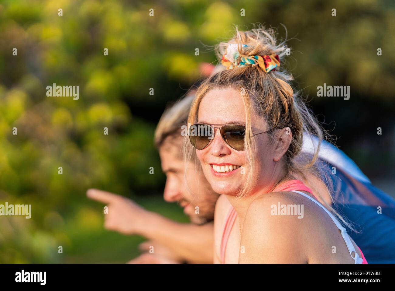 Femme portant des lunettes de soleil souriant à côté d'amis Banque D'Images