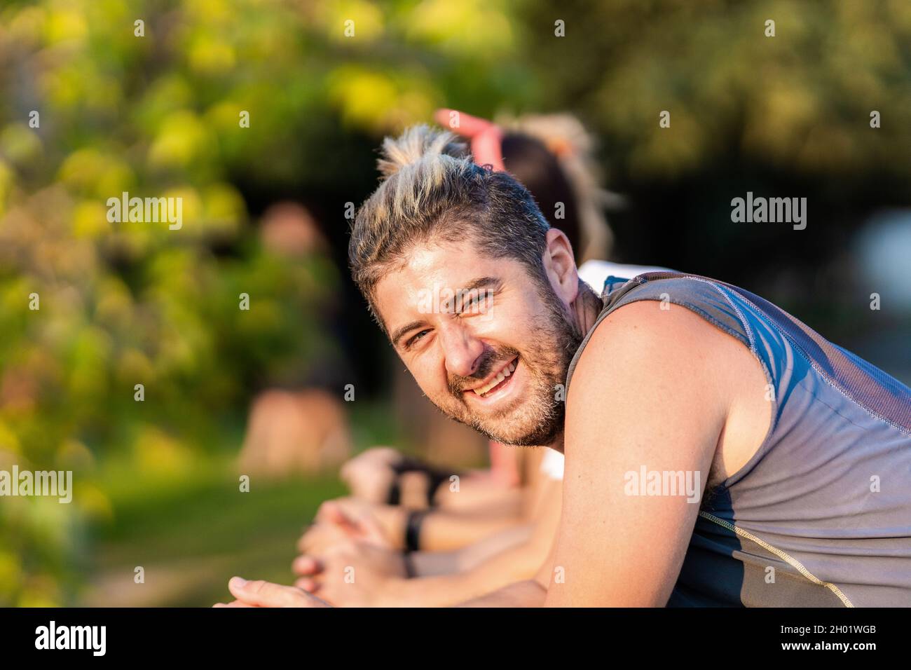 Homme dans des vêtements de sport souriant à l'extérieur de l'appareil photo Banque D'Images