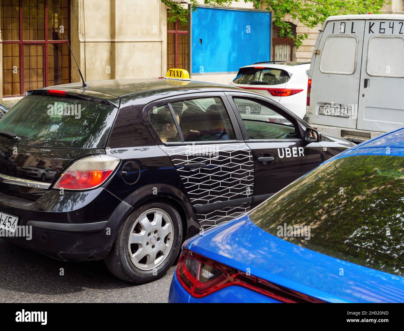 Vue latérale du bâtiment noir Opel Astra avec étiquette Uber taxi sur le  bâtiment transportant des passagers dans la capitale azérie Photo Stock -  Alamy