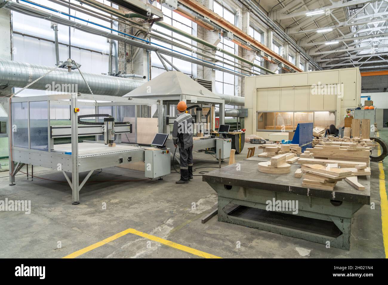 Employé de la machine à découper le bois automatisée dans l'usine de travail du bois.Fabrication professionnelle de menuiserie industrielle. Banque D'Images