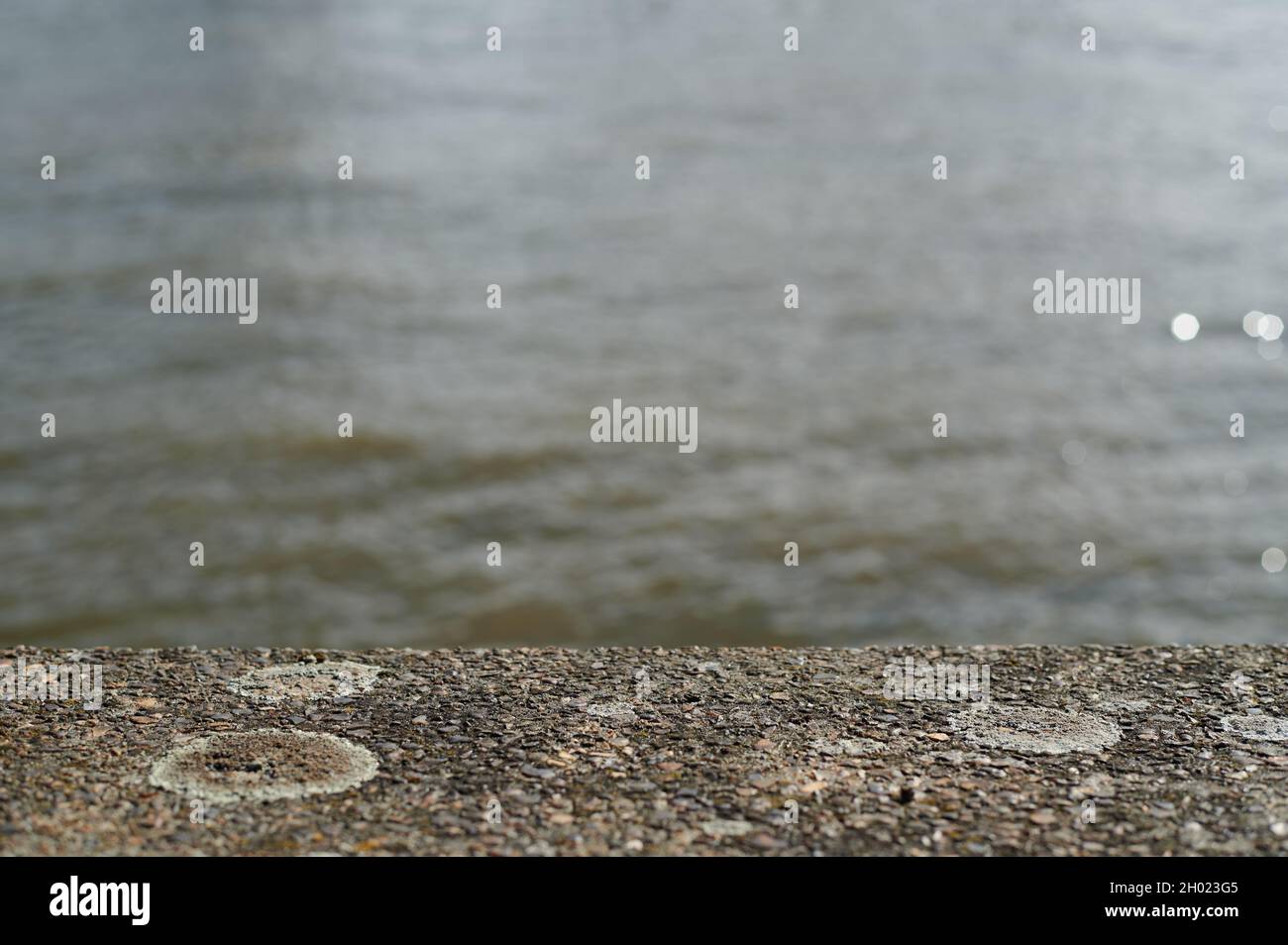 Coloration brune / coloration à la scène de rivière et d'eau hors foyer avec le premier plan de béton Banque D'Images