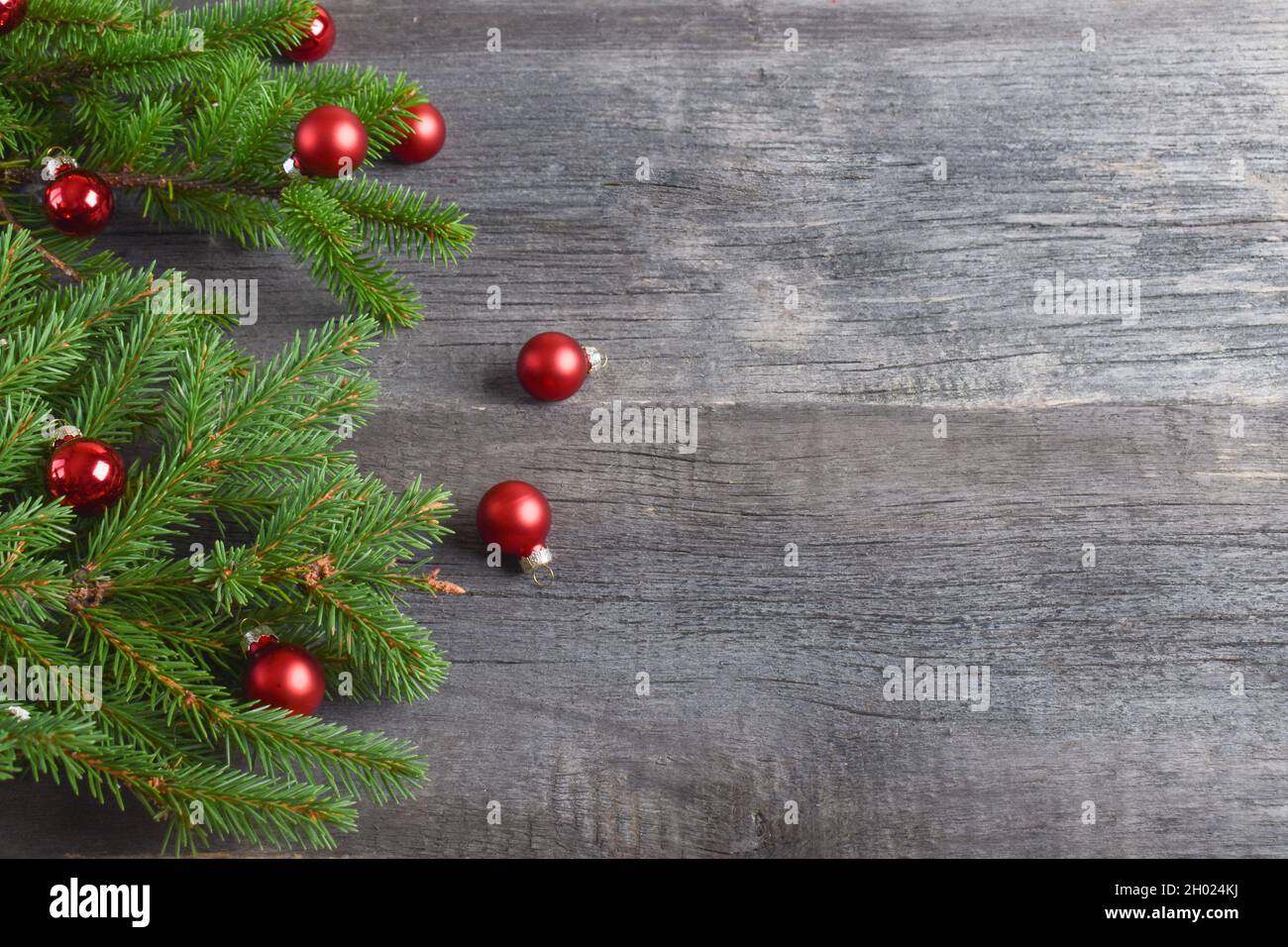 Une branche de sapin avec des boules de verre sur un fond en bois.Joyeux Noël.Fond festif. Banque D'Images