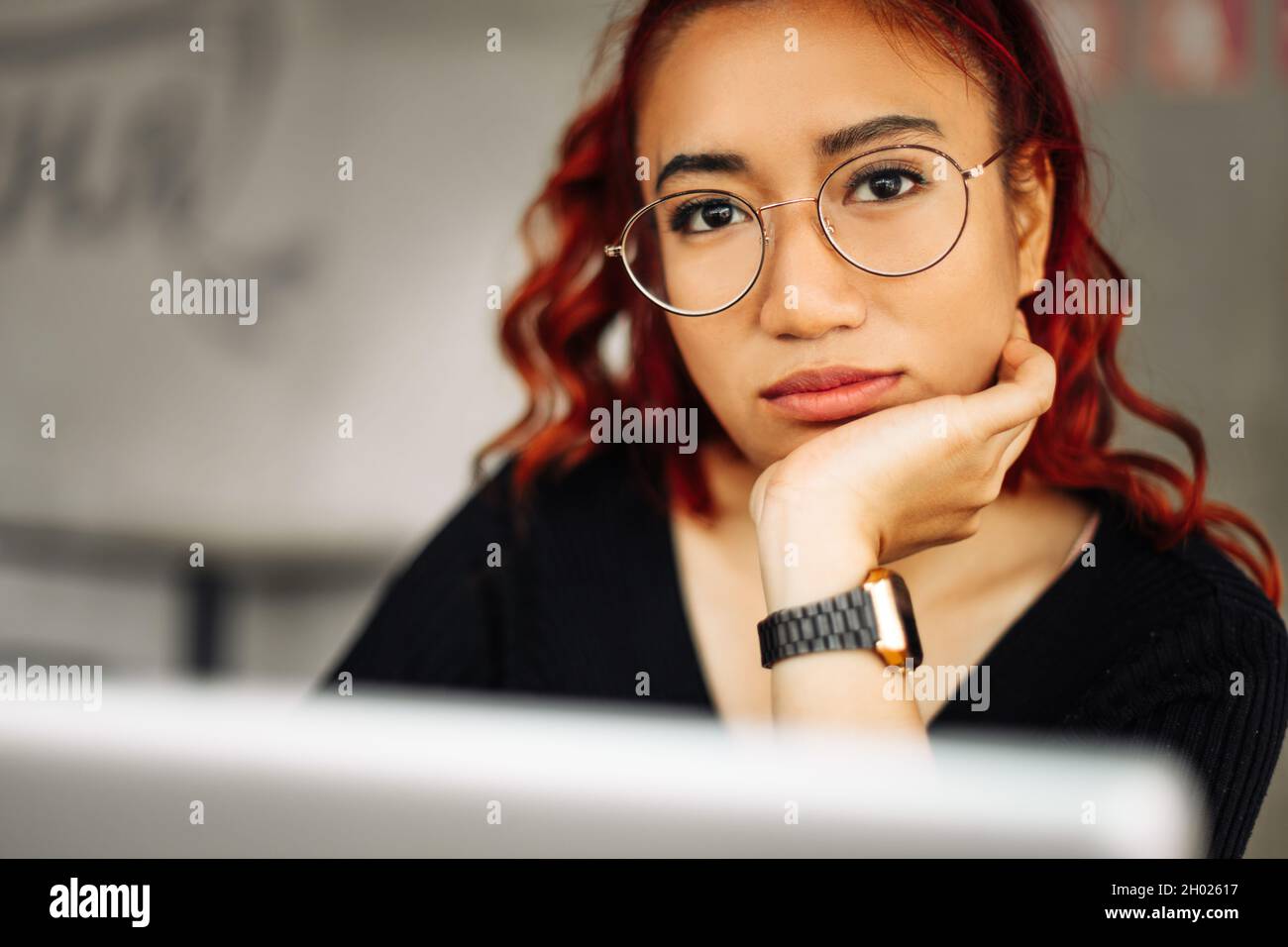 Image de la magnifique femme asiatique qui porte des lunettes souriant  lorsqu'elle travaille avec un ordinateur portable au bureau Photo Stock -  Alamy